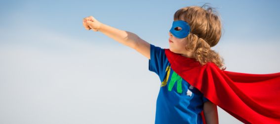 child dressed as a super hero with a mask and cape
